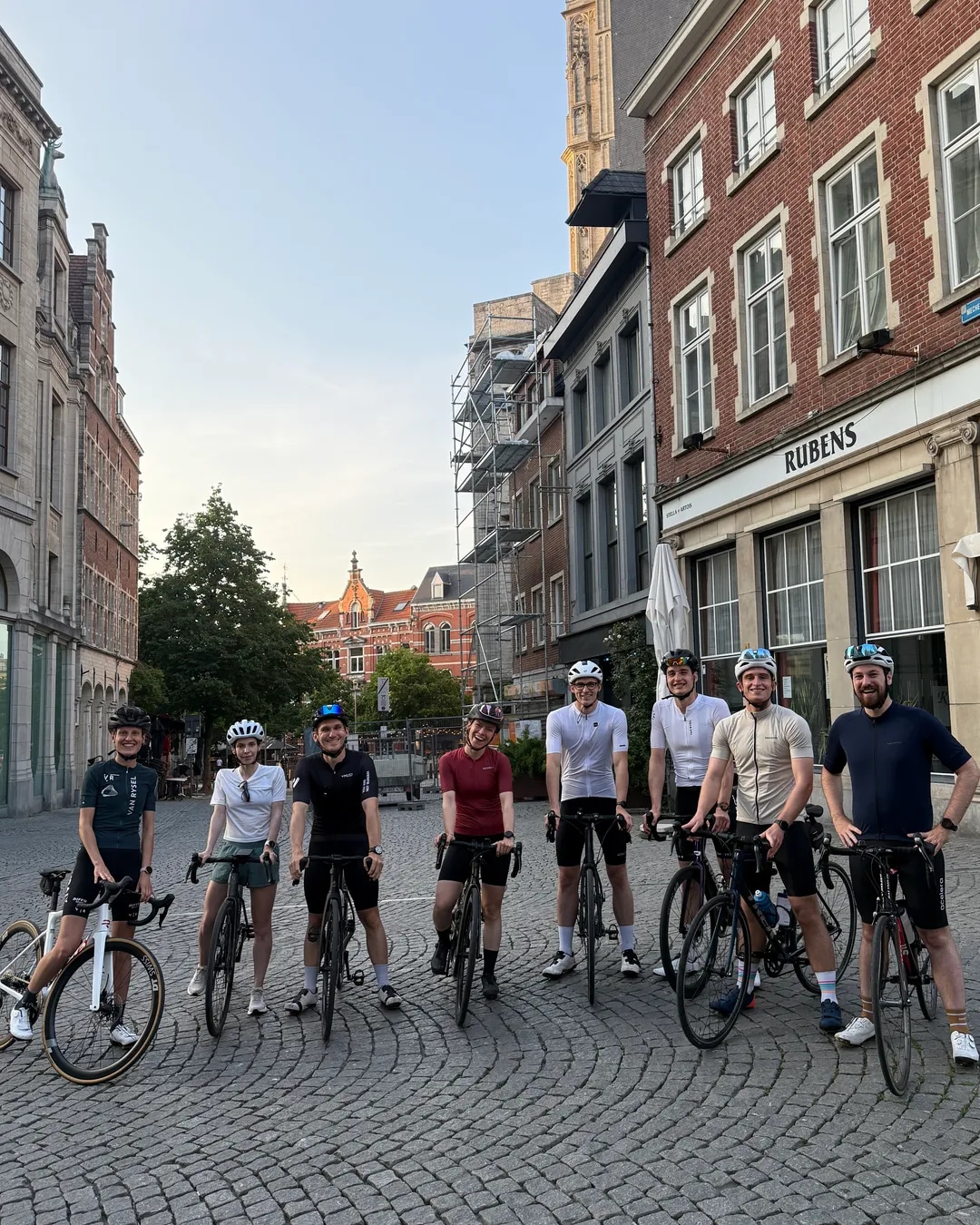 Cyclists lined up with their bikes on a cobbled city square before a Wyder ride